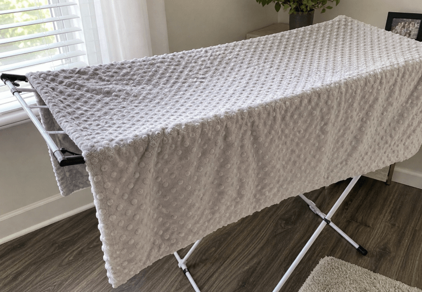 minky blanket air drying on a rack indoors near a window after washing